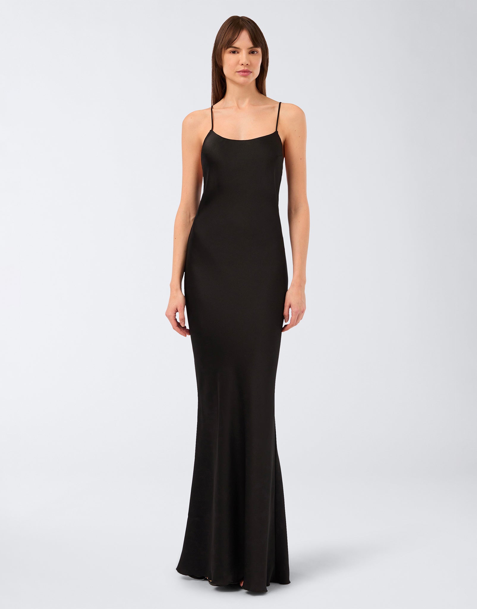 Frontal view of the Ninfea Maxi Dress, a timeless black crepe satin slip dress with thin straps, wide neckline, and floor-length mermaid-effect silhouette.