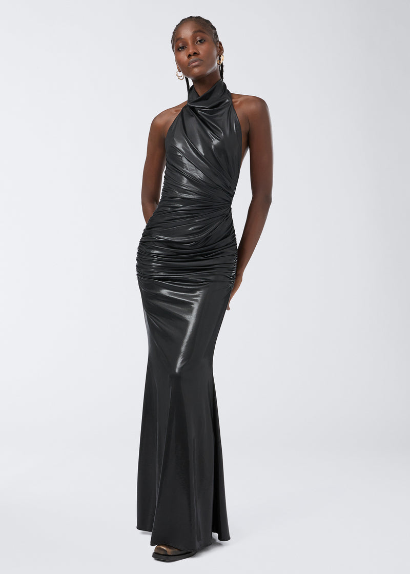 
                          Frontal view of the Stella Maxi Dress, a figure-hugging black shiny liquid jersey dress with a draped turtleneck and ruched details, worn by a woman.
                        