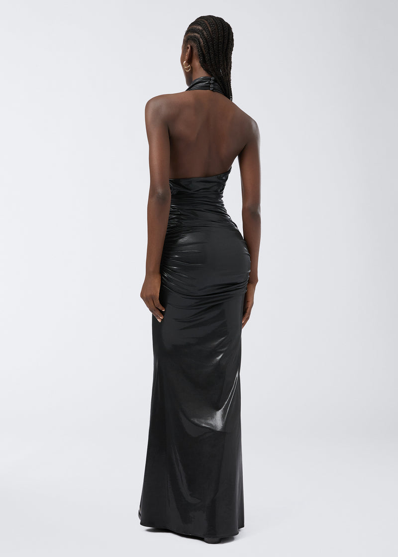 
                          Rear view of a woman wearing the Stella Maxi Dress, a black shiny liquid jersey gown with a dramatic open back and fitted silhouette against a plain background.
                        