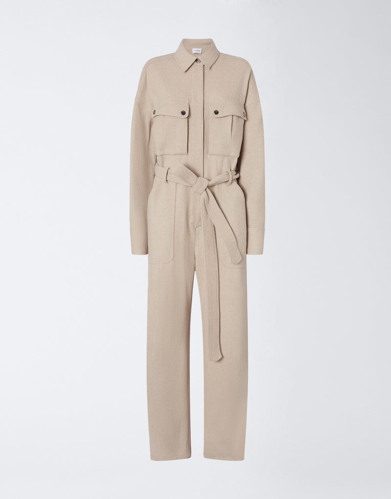 
                          Frontal view shows the Xandra Jumpsuit in sand-colored felted jersey, with a pointed collar, concealed button placket, long sleeves, patch pockets, and a matching belt.
                        