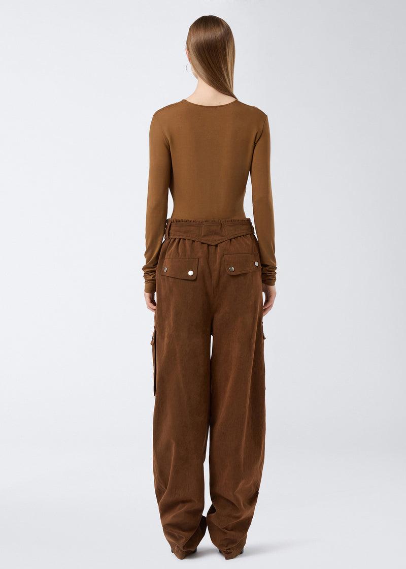 
                          Rear view showing a model wearing Xandra Maxi Pants in cigar-colored, stone-washed cotton, with elasticated waist, back welt pockets with snap buttons, and wide legs.
                        
