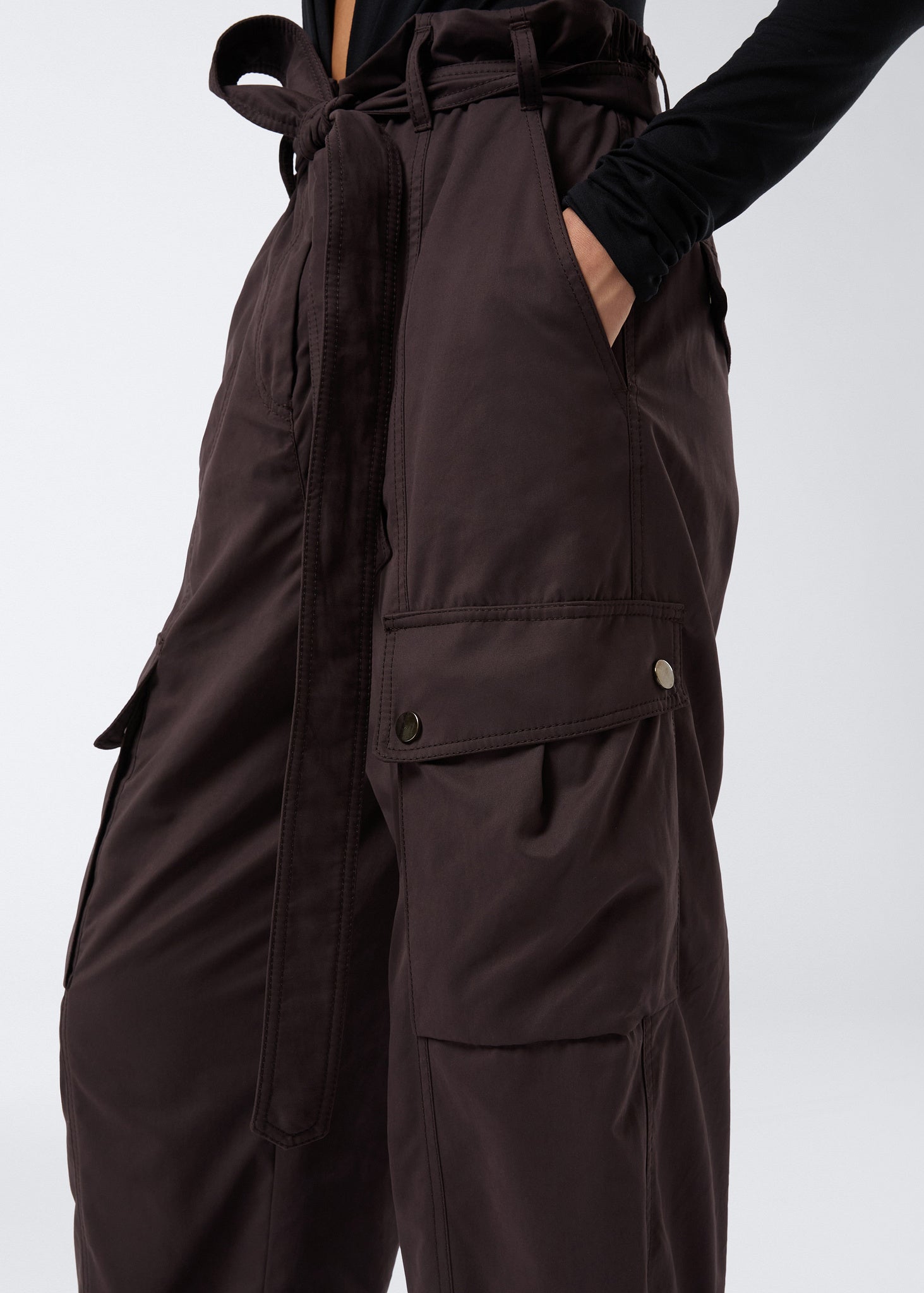 Side view of Xandra Maxi Pants in dark brown suede-touch nylon, featuring buttoned cargo pockets, adjustable belt, and elasticated back waist.
