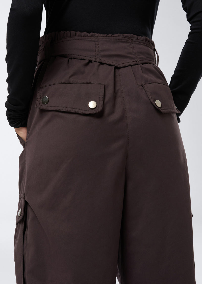
                          Rear view of the Xandra Maxi Pants in dark brown suede-touch nylon, showcasing buttoned flap pockets on the back and an elasticated waistband.
                        