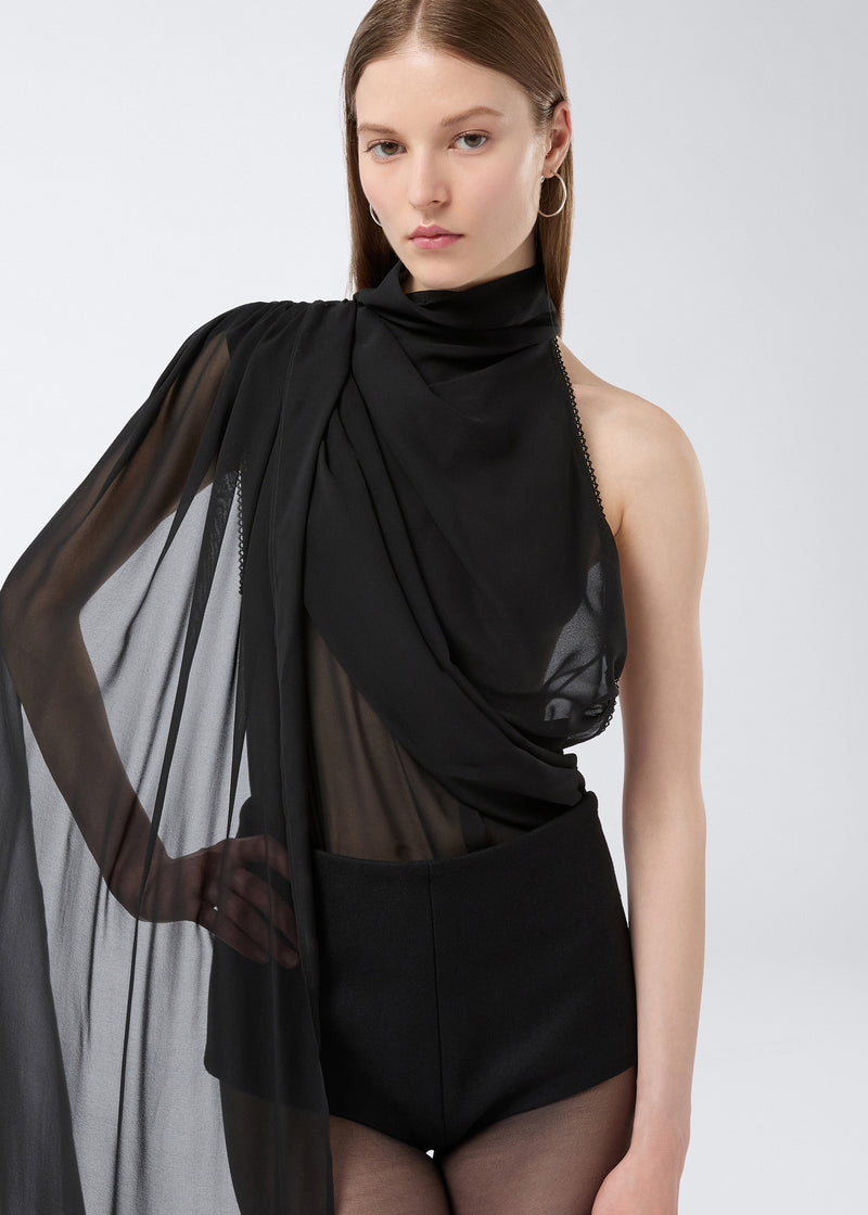 
                          Frontal view of a model wearing Tami Culottes, made from black felted wool with a high waist and structured fit, paired with a sheer black top.
                        