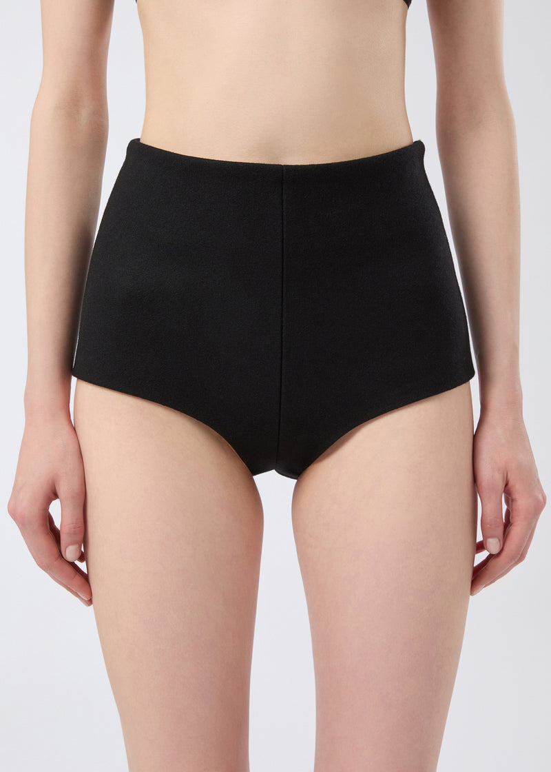 
                          Frontal view shows a model wearing Tami Culottes in structured black felted wool, featuring a high waist and smooth, minimal finish.
                        