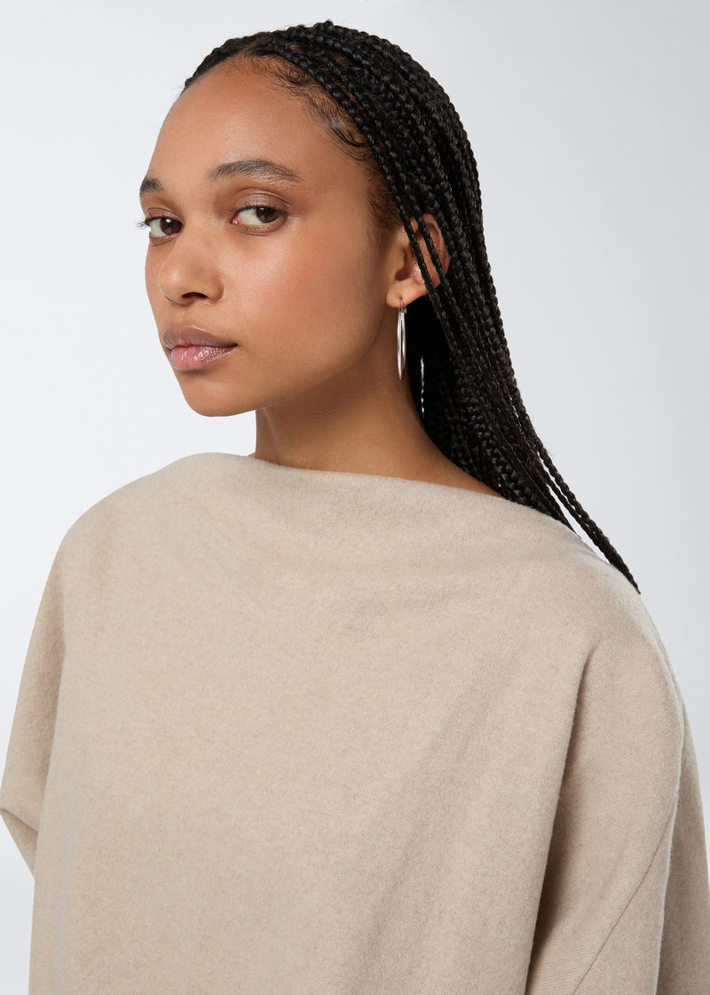 
                          Frontal view showing a model wearing the Wisteria Top in sand-colored soft felted jersey, featuring a high boat neckline and long sleeves.
                        