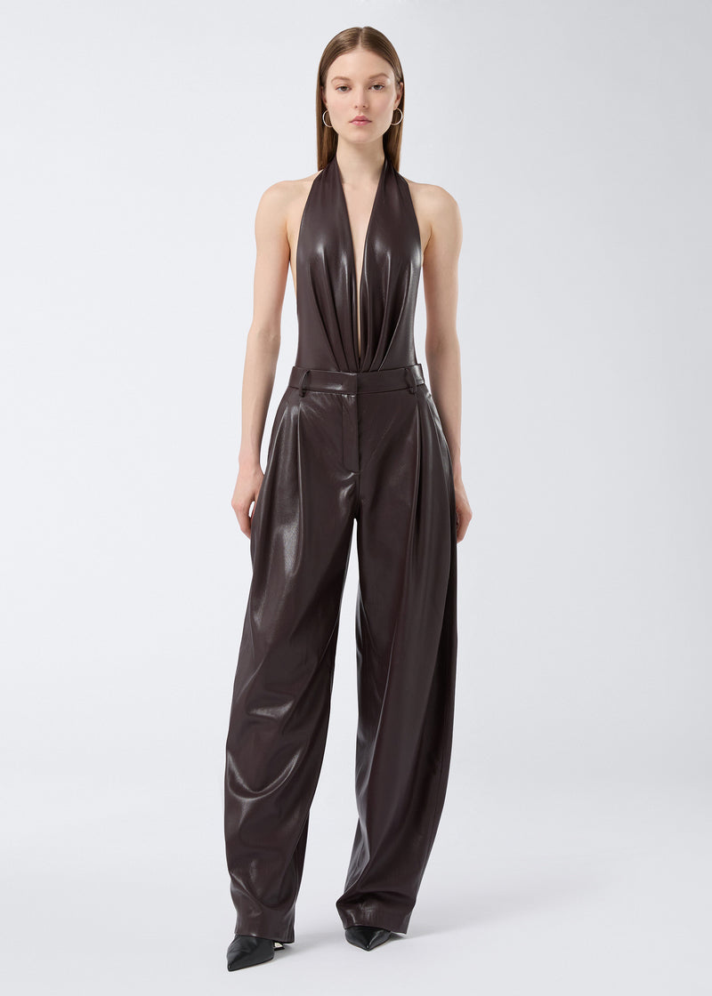 
                          Frontal view of a woman wearing the Zendaya Bodysuit in cabernet vegan leather, featuring a sleeveless, plunging V-neck with halterneck strap and deep front pleats.
                        