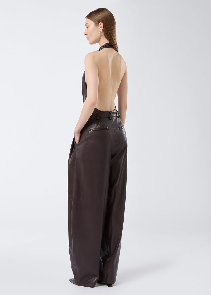 
                          Rear view of a woman wearing the Zendaya Bodysuit in cabernet vegan leather, featuring a halterneck strap, backless design, and sleeveless cut.
                        