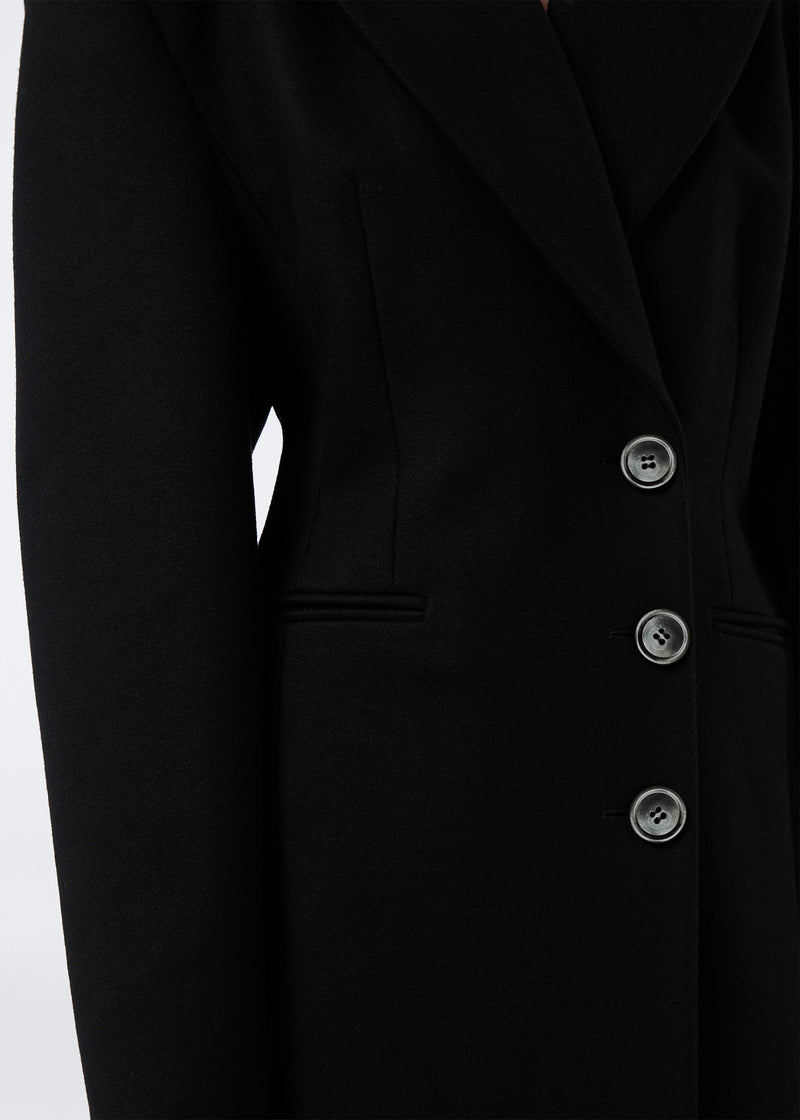 
                          Detail view of the Ottavia Coat showcasing the black felted wool fabric, pointed lapel collar, and three front buttons for single-breasted closure.
                        