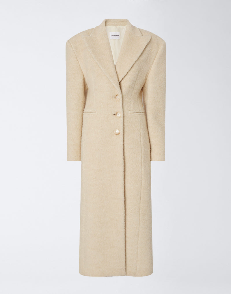 
                          Frontal view shows the Ottavia Coat in ivory wool twill, featuring padded shoulders, peaked lapel collar, button closure, and a tailored hourglass silhouette.
                        