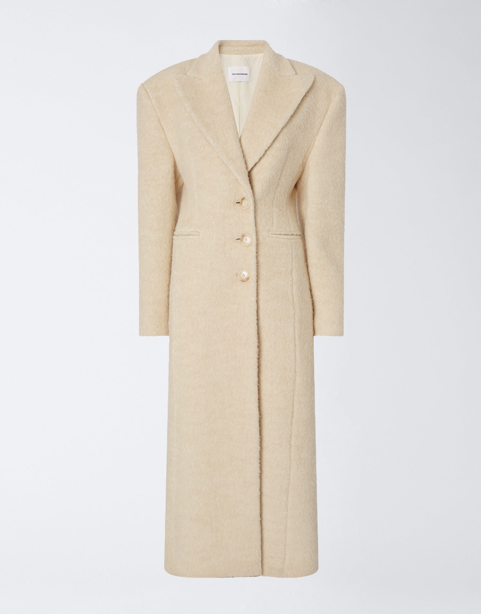 Frontal view shows the Ottavia Coat in ivory wool twill, featuring padded shoulders, peaked lapel collar, button closure, and a tailored hourglass silhouette.