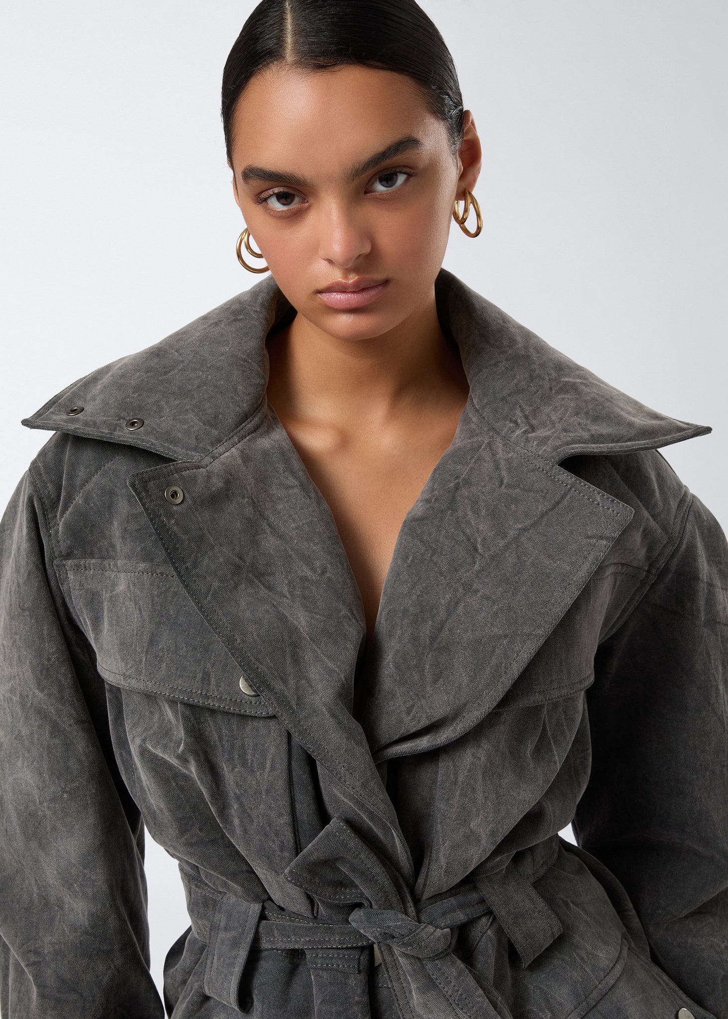 Frontal view of the Xandra Jacket in ardesia stone-washed cotton, featuring an oversized spread collar, matching belt, button flap pockets, and buttoned cuffs.
