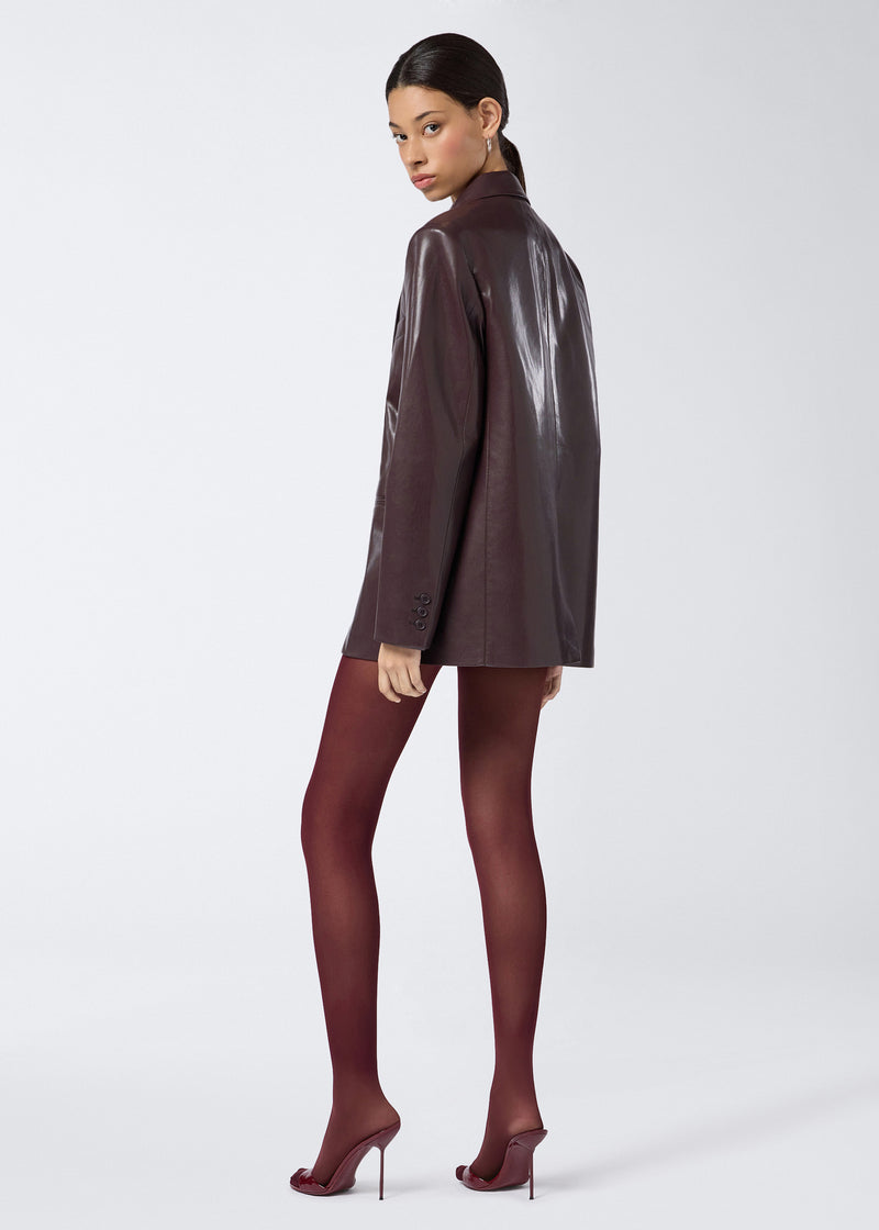 
                          Rear view showing a model wearing the Guia Blazer in cabernet vegan leather, featuring an oversized fit, notched lapel, and buttoned cuffs.
                        