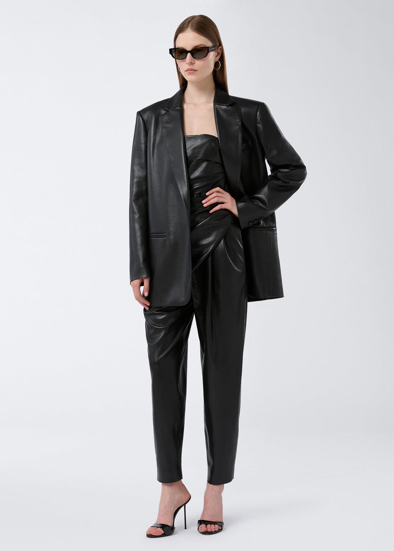 
                          Frontal view: Model wearing the Guia Blazer in black vegan leather, showcasing its oversized fit, notched lapel, welt chest pocket, and jetted waist pockets.
                        