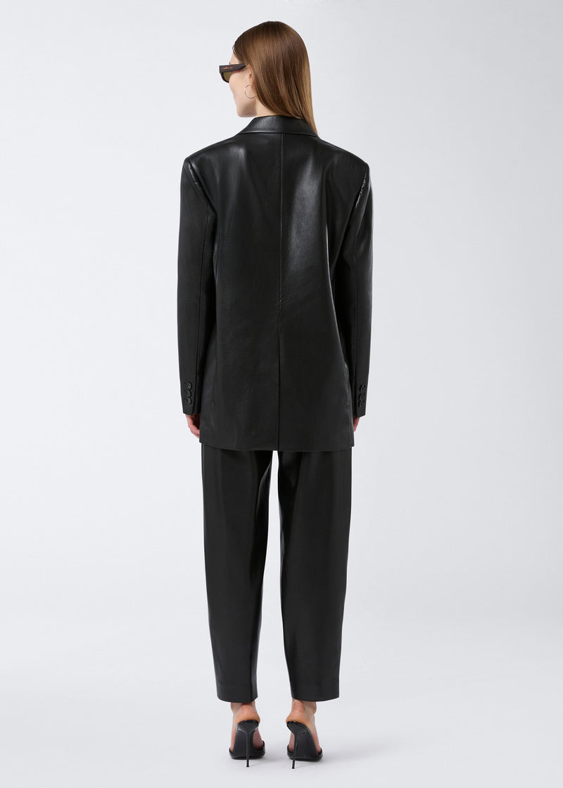 
                          Rear view of woman wearing Guia Blazer in black vegan leather, showing an oversized fit, long sleeves, back vent, and classic tailored silhouette.
                        
