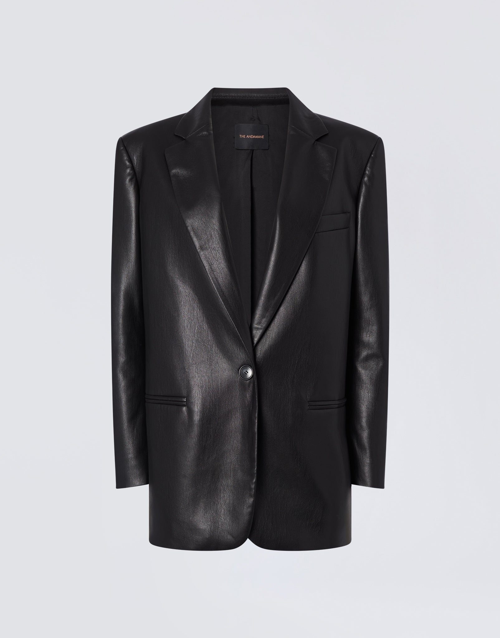 Frontal view of the Guia Blazer, an oversized black vegan leather blazer featuring a notched lapel, single-breasted one-button closure, and welt pockets.