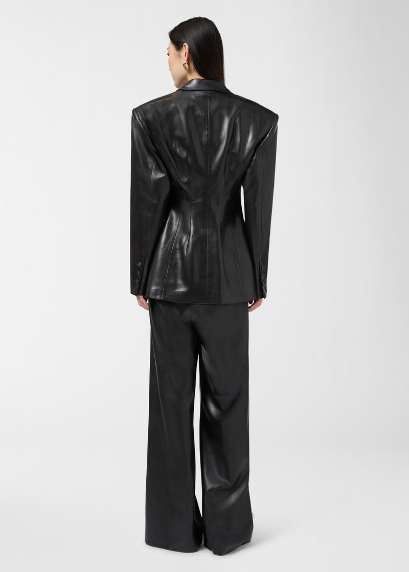 Rear view of the Ottavia Blazer showing a black vegan leather blazer with exaggerated shoulders, a cinched waist, and a sleek tailored fit over matching trousers.