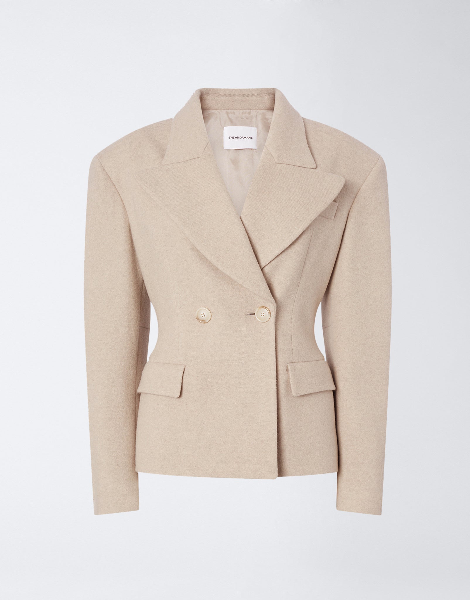 Frontal view of the Tillie Blazer in sand-colored soft felted jersey, featuring a double-breasted closure, wide lapel, flap pockets, and buttoned cuffs.