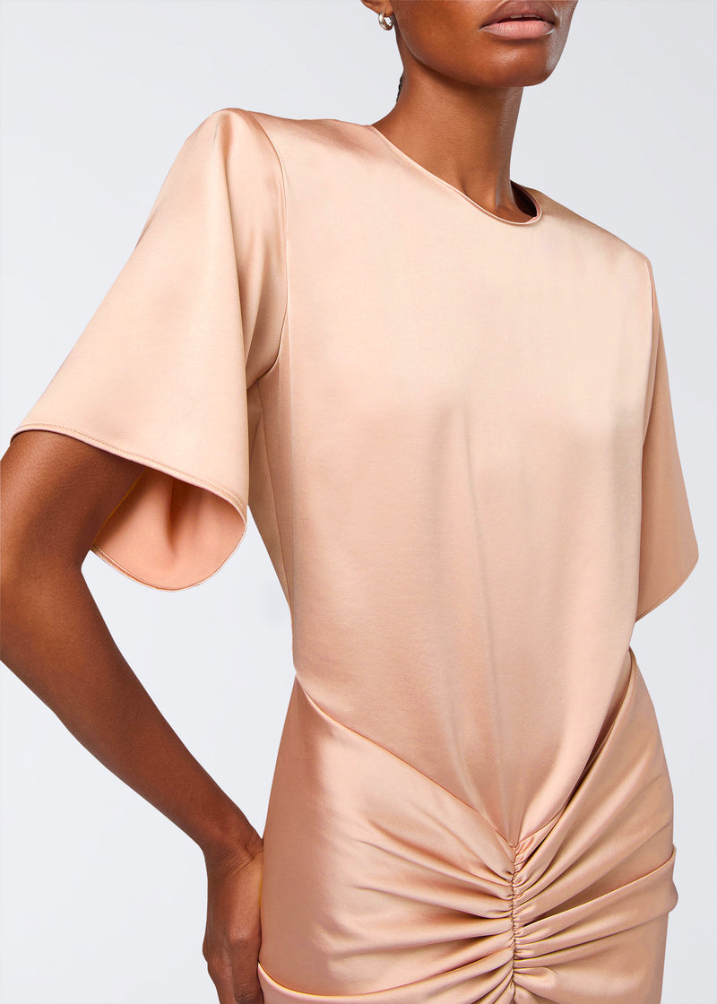 Frontal view of the Iris Maxi Dress showing a blush liquid satin women’s maxi dress with a high neckline, structured shoulders, short sleeves, and gathered ruching at the waist.