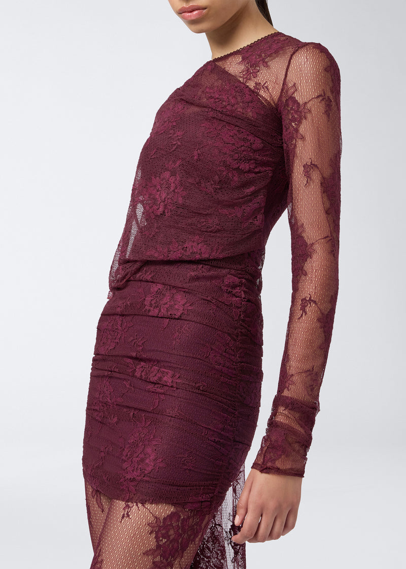 
                          Frontal view shows a model wearing the Xenia Mini Dress in cabernet lace with long sheer sleeves, built-in straps, and all-over ruching.
                        