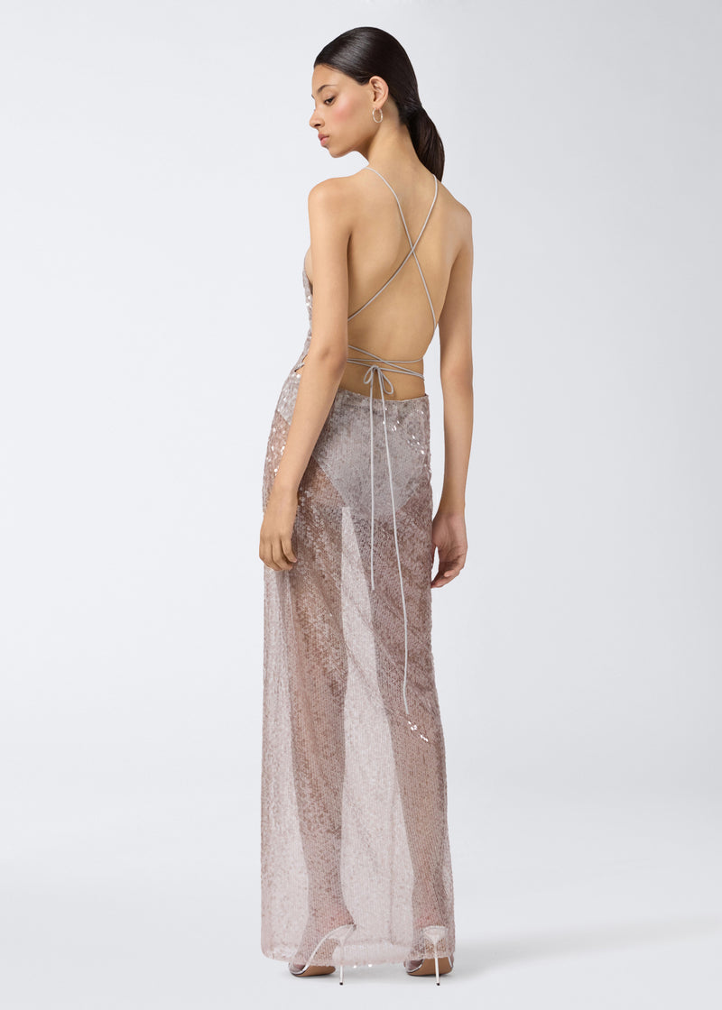 
                          Rear view of a woman wearing the West Maxi Dress, showcasing its steel-colored sequins, crisscross back straps, open back, and floor-length design.
                        