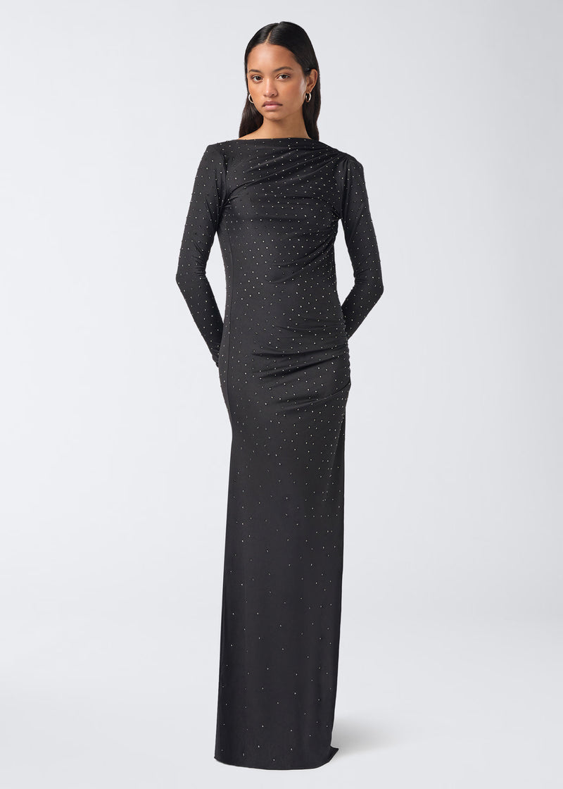 
                          Frontal view of a woman standing and wearing the Sophie Maxi Crystal Dress, a long black jersey maxi dress with long sleeves and all-over sparkling crystals.
                        
