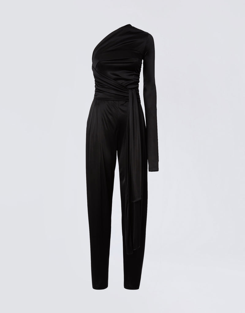 
                          Frontal view of the Webster Jumpsuit, a black shiny jersey women’s piece with one-shoulder, one long sleeve, a waist-wrapping belt, and straight-leg pants.
                        
