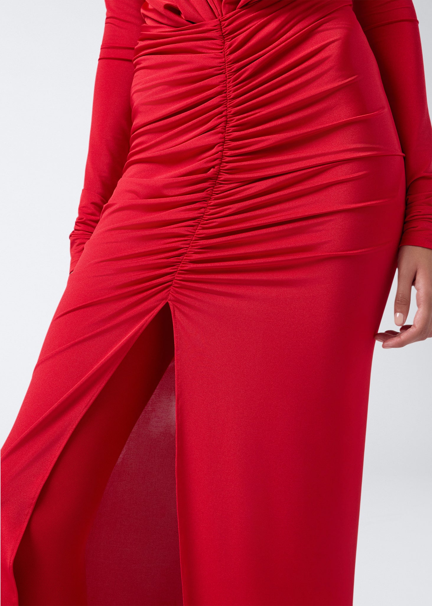 Detail view shows the lower half of the Zelda Maxi Dress in red, featuring horizontal ruching, a front opening, and soft, flowing jersey fabric.