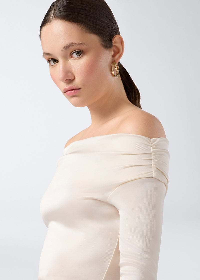 
                          Frontal detail view of Wendell Mini Dress in ivory shiny jersey, featuring an off-the-shoulder neckline, visible ruching on the sleeve, and long sleeves.
                        