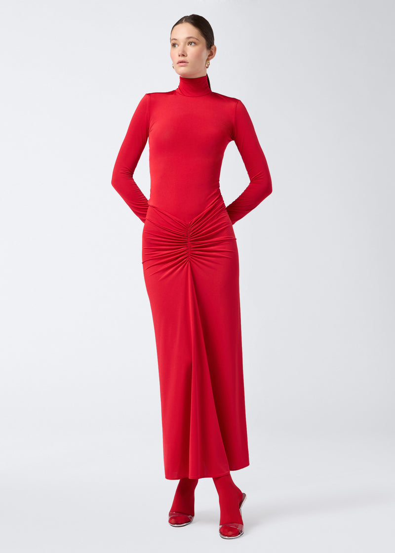 
                          Frontal view of the Warwick Maxi Dress, a red jersey dress featuring a turtleneck, long sleeves, and ruching at the waist for a mermaid-effect skirt.
                        