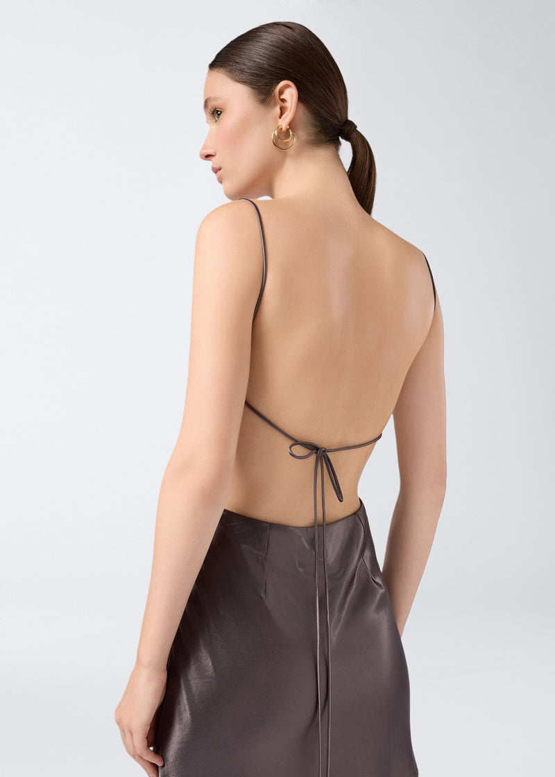 
                          Rear view of the Willa Mini Dress in steel-colored shiny satin, showcasing the open back, thin adjustable straps, and tie detail at the lower back.
                        