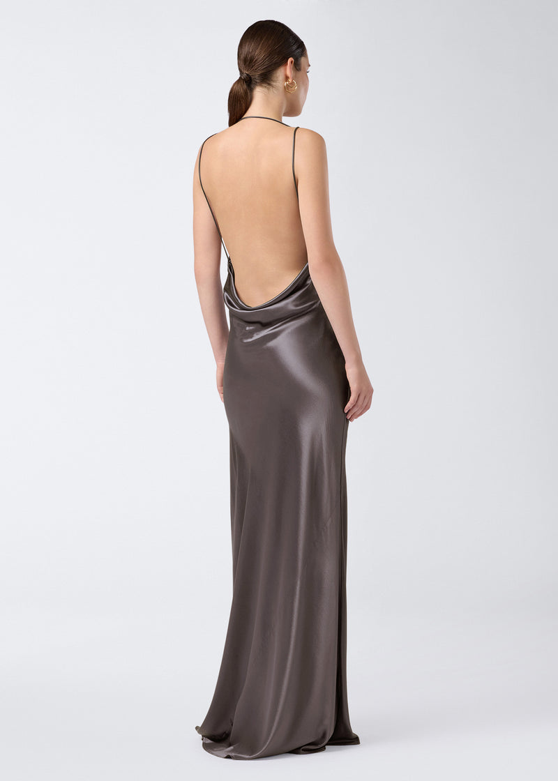 
                          Rear view shows a woman wearing the Vera Maxi Dress in steel-colored shiny satin, featuring a low open back, adjustable thin straps, and a floor-length silhouette.
                        