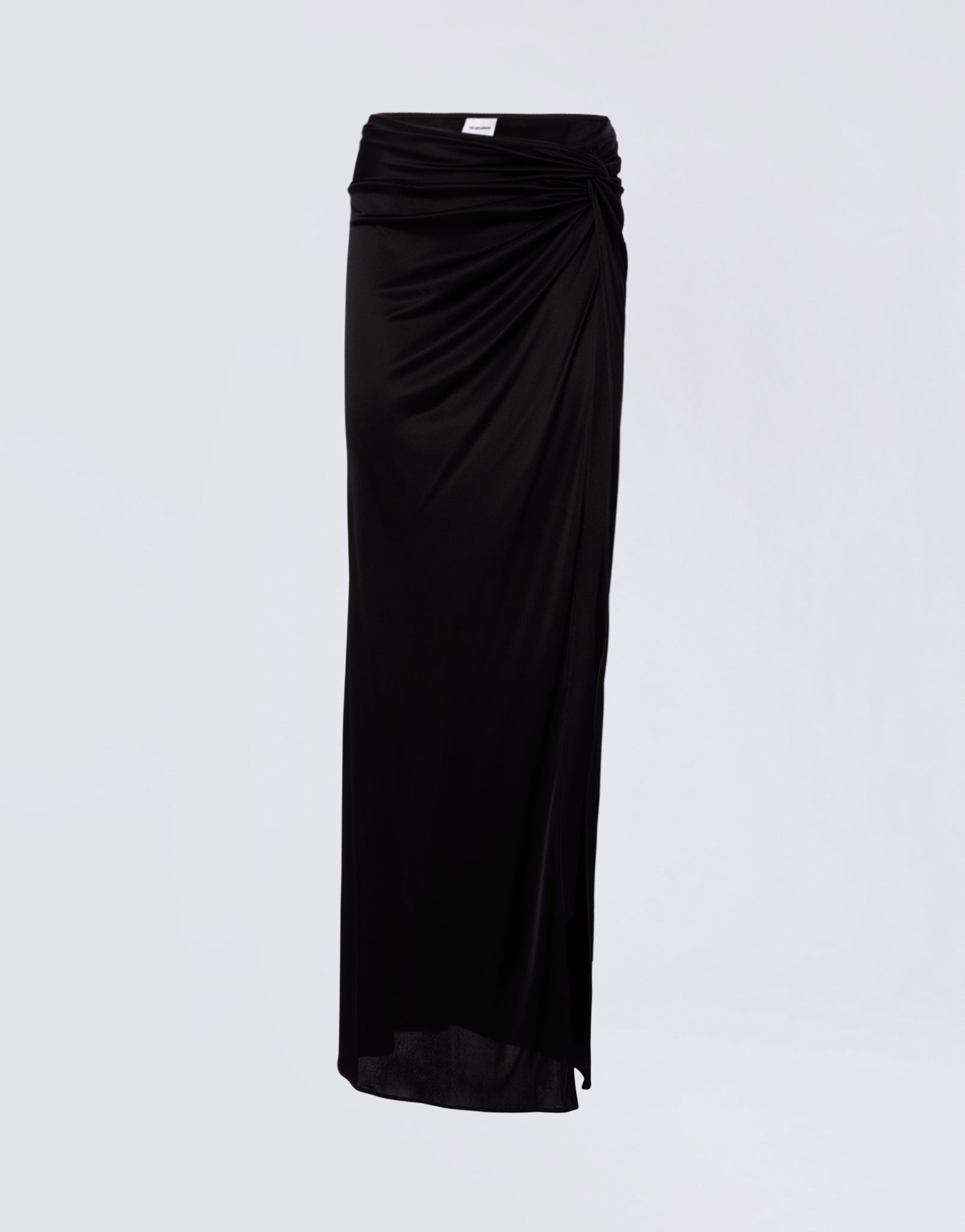 Frontal view shows the Zohra Maxi Skirt in black shiny jersey with high-rise waist, side knot detail, draped design, and ruched back contour.