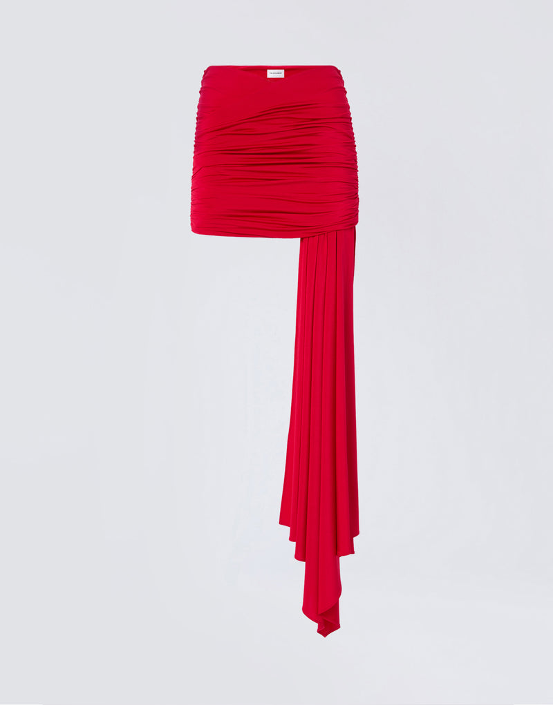
                          Frontal view. Wendell Mini Skirt in vibrant red lightweight jersey, featuring all-over ruching, a cross-over accent, and a long asymmetric draped panel from the hem.
                        