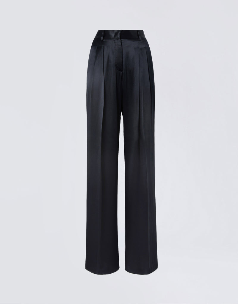 
                          Frontal view of Nathalie Pants, featuring black shiny satin wide legs, front pleats, belt loops, and tailored details against a light background.
                        
