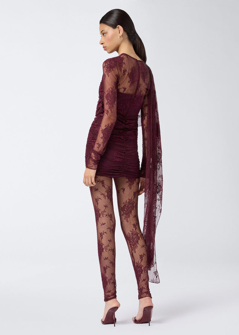 
                          Rear view of a woman wearing Zillah Leggings in sheer cabernet lace with a mid-rise waist, solid trim, and full-length legs down to the ankles.
                        
