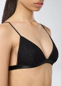 Detail view showing the New Guenda Bra in black lace, featuring micro lace trim on the cups, adjustable straps, and a band under the bust.