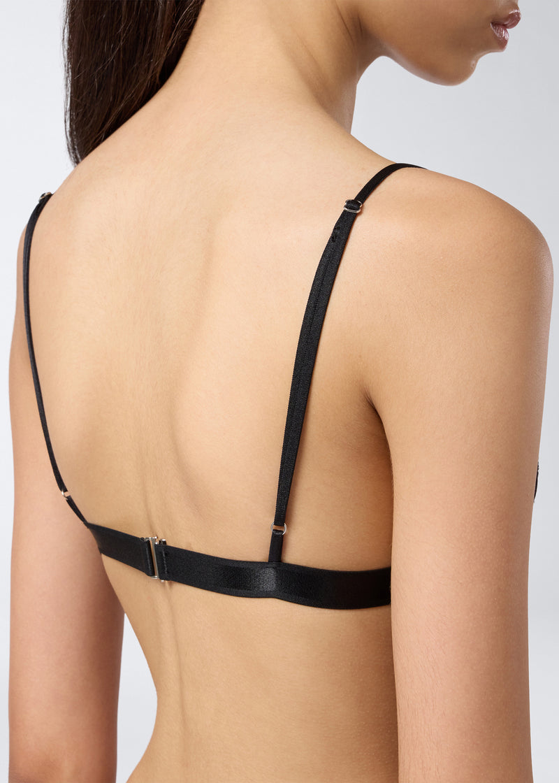 
                          Rear view shows a woman wearing the New Guenda Bra in black lace, featuring adjustable shoulder straps and a clasp closure at the back.
                        