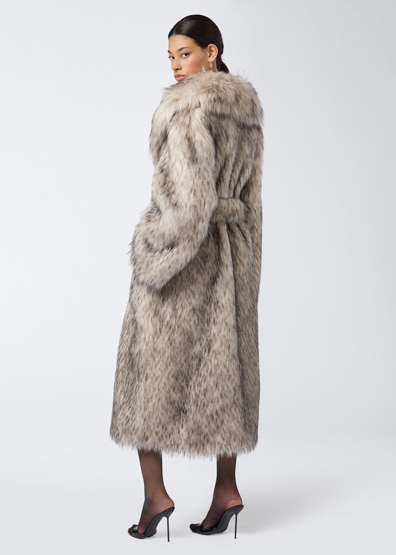
                          Rear view of a woman wearing the Winter Maxi Coat made from greige faux fur, featuring an oversized fit, large shawl lapel collar, and belted waist.
                        