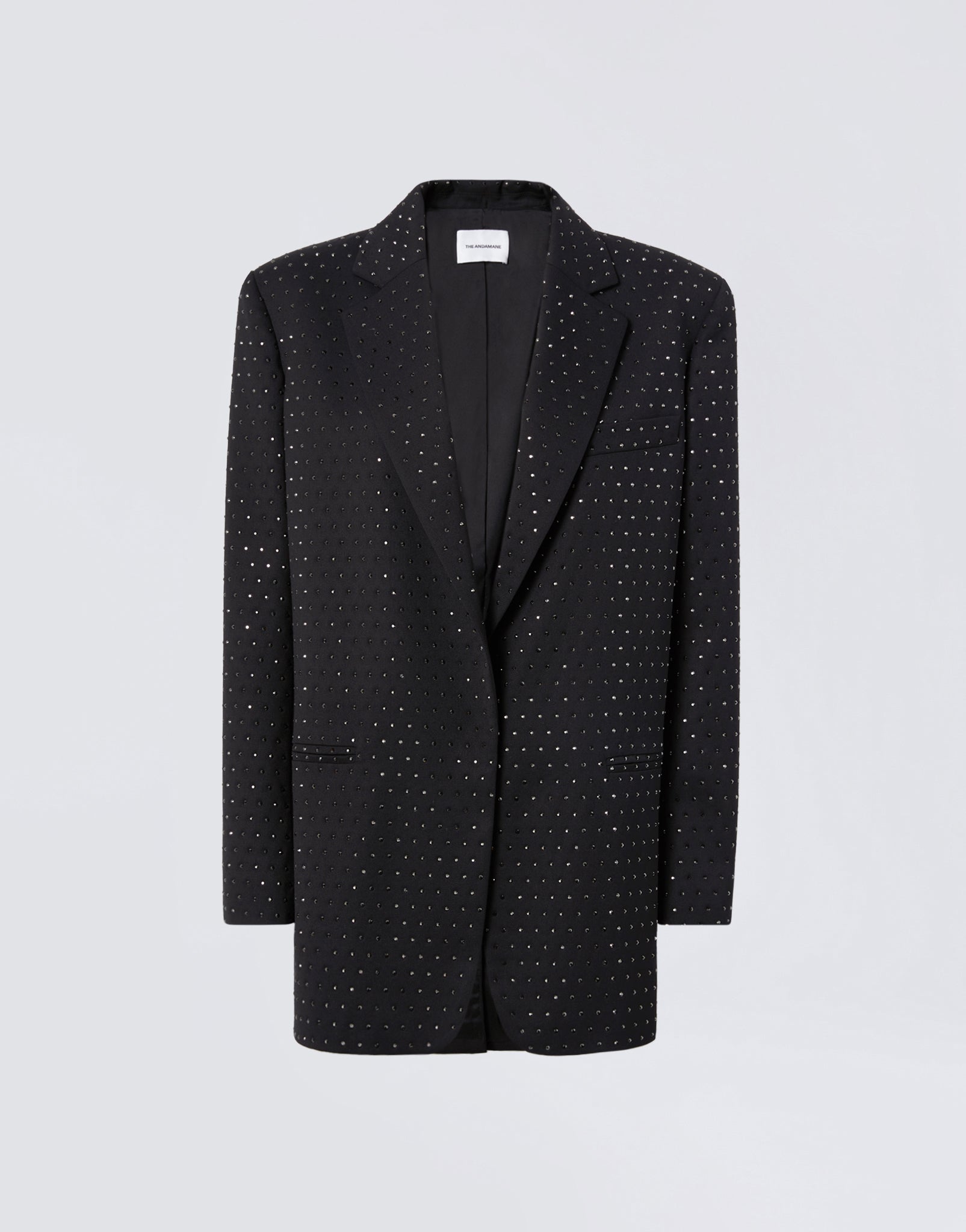 Frontal view of the Guia Blazer, a black oversized women&#39;s blazer in wool and gabardine blend with crystal embellishments, notched lapel, padded shoulders, and three front pockets.