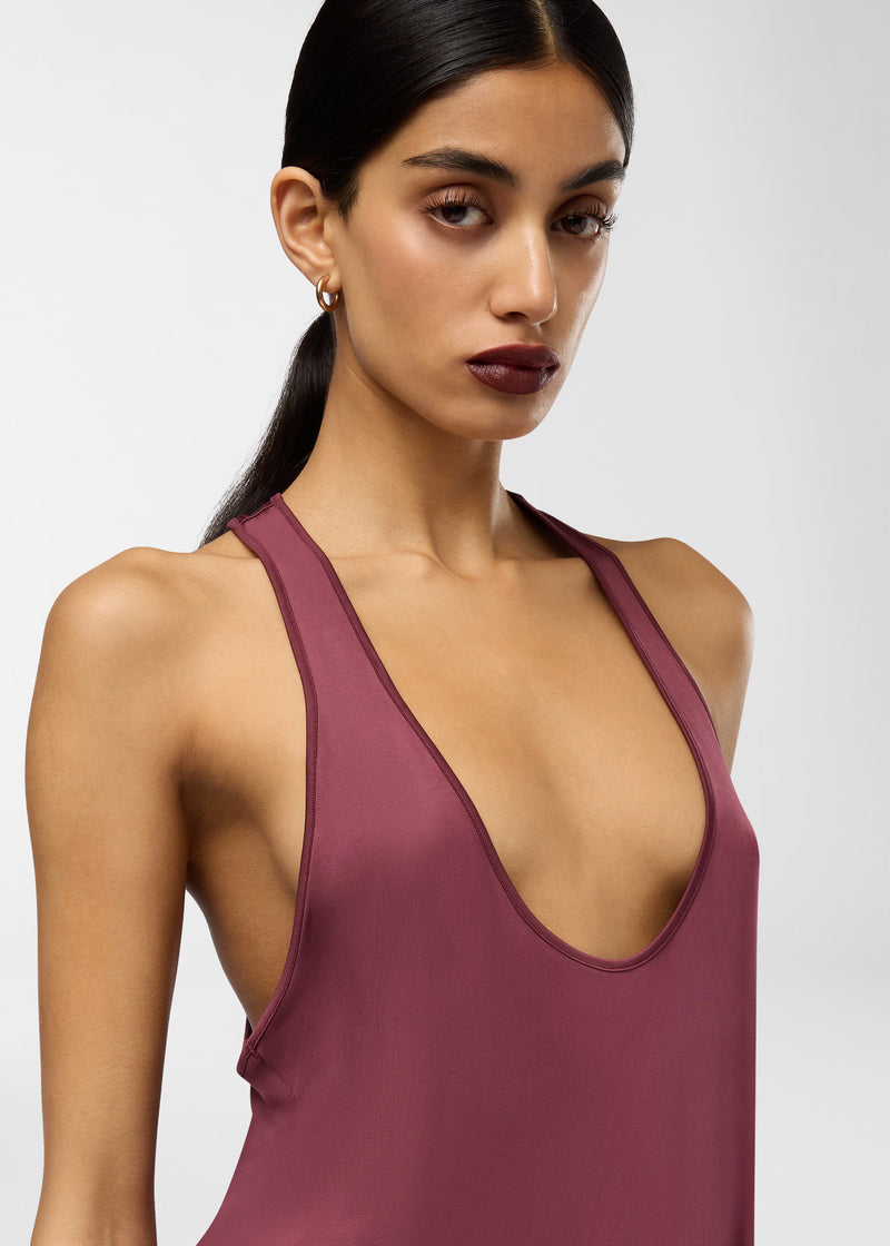 Frontal view — Juno Maxi Dress displayed on a model, revealing a plunging scoop neckline and racerback, draping in rouge noir jersey against a neutral studio backdrop.