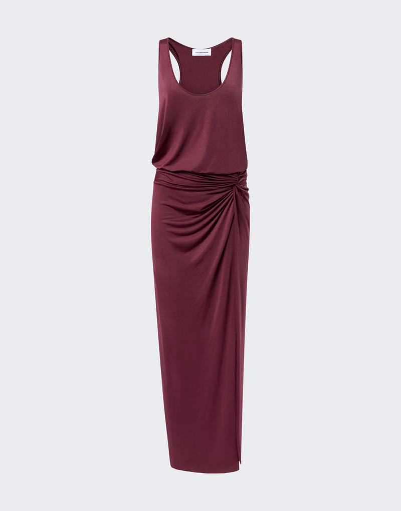 Frontal view. Juno Maxi Dress displayed flat on neutral background, showing sleeveless racerback bodice with plunging scoop, knotted side ruching, high leg slit, and long fitted skirt.