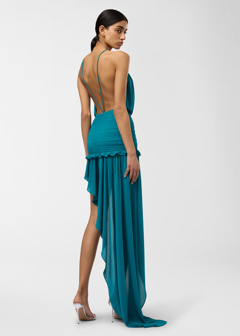 Rear view — Model wearing Ines Maxi Dress in jade, exposing scooped back with thin double straps, smocked waist and asymmetrical floor-length cascading skirt.