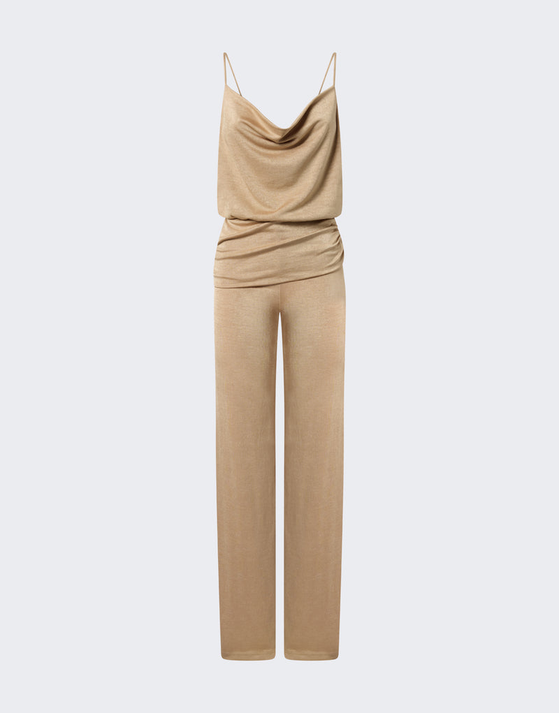 Frontal view of Carla Jumpsuit displayed on pale-gray background, metallic-gold cowl-neck bodice with thin straps, fitted waist drape and loose, floor-length wide-leg pants.