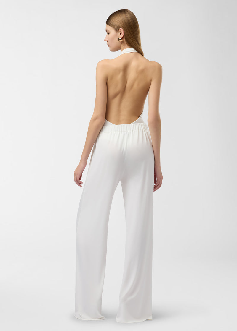 Rear view — Lana Pants: off-white wide-leg pants worn by a standing model, high-rise elasticized waistband with concealed side-slit pockets, floor-length drape on plain white studio background.