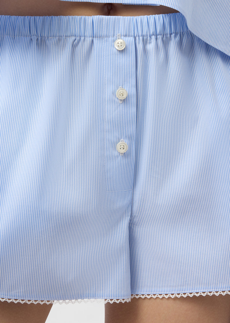 Frontal view: Arabella Shorts showing elasticated low-rise waistband, decorative button placket, side slit pocket and micro lace-trimmed hem in light blue and white micro-striped cotton poplin.