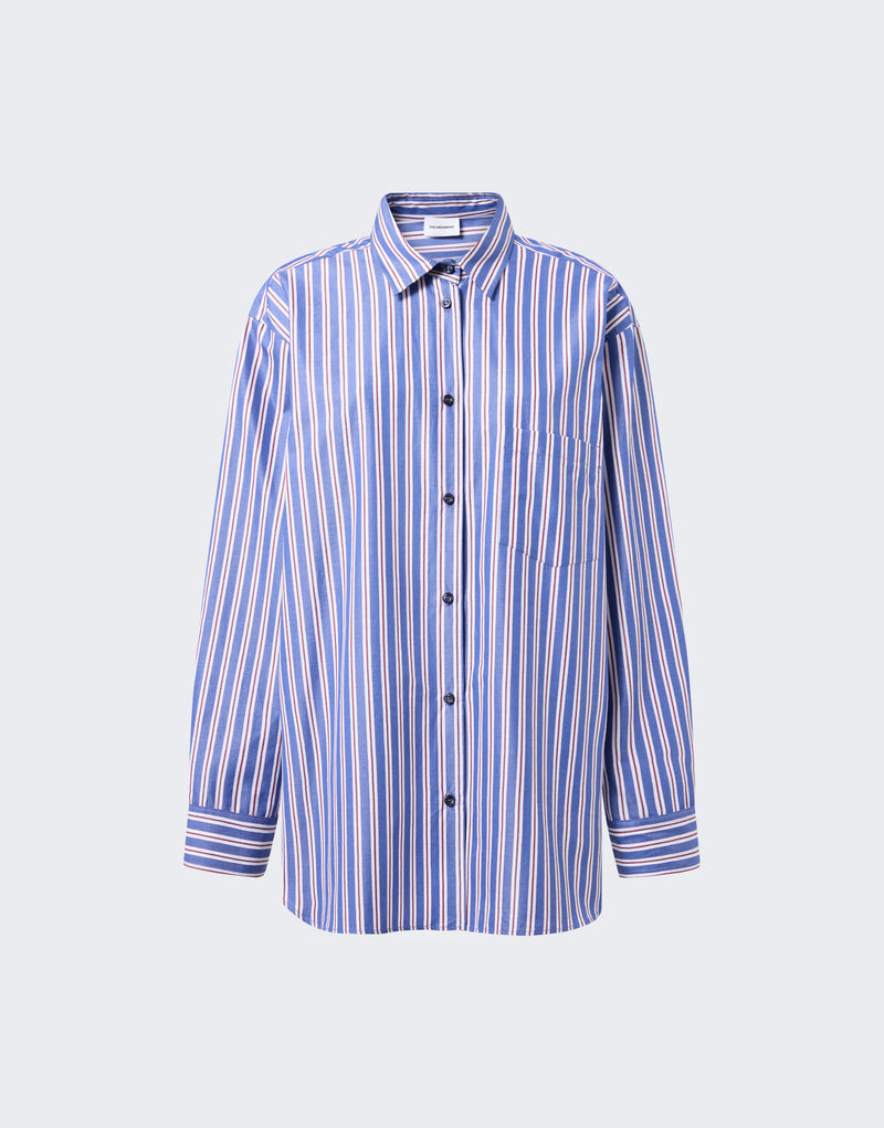 Frontal view: New Georgiana Shirt displayed flat against a pale background, showing oversized blue and rouge noir vertical maxi-stripes, pointed collar, central button placket, and a chest patch pocket.