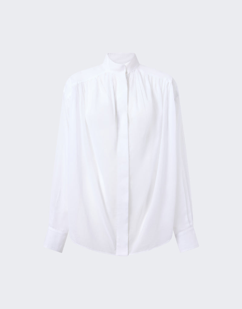 Frontal view: Rania Shirt, an oversized white cotton muslin shirt, displayed flat on neutral background, showing mandarin collar, concealed button placket, shoulder and cuff pleats.