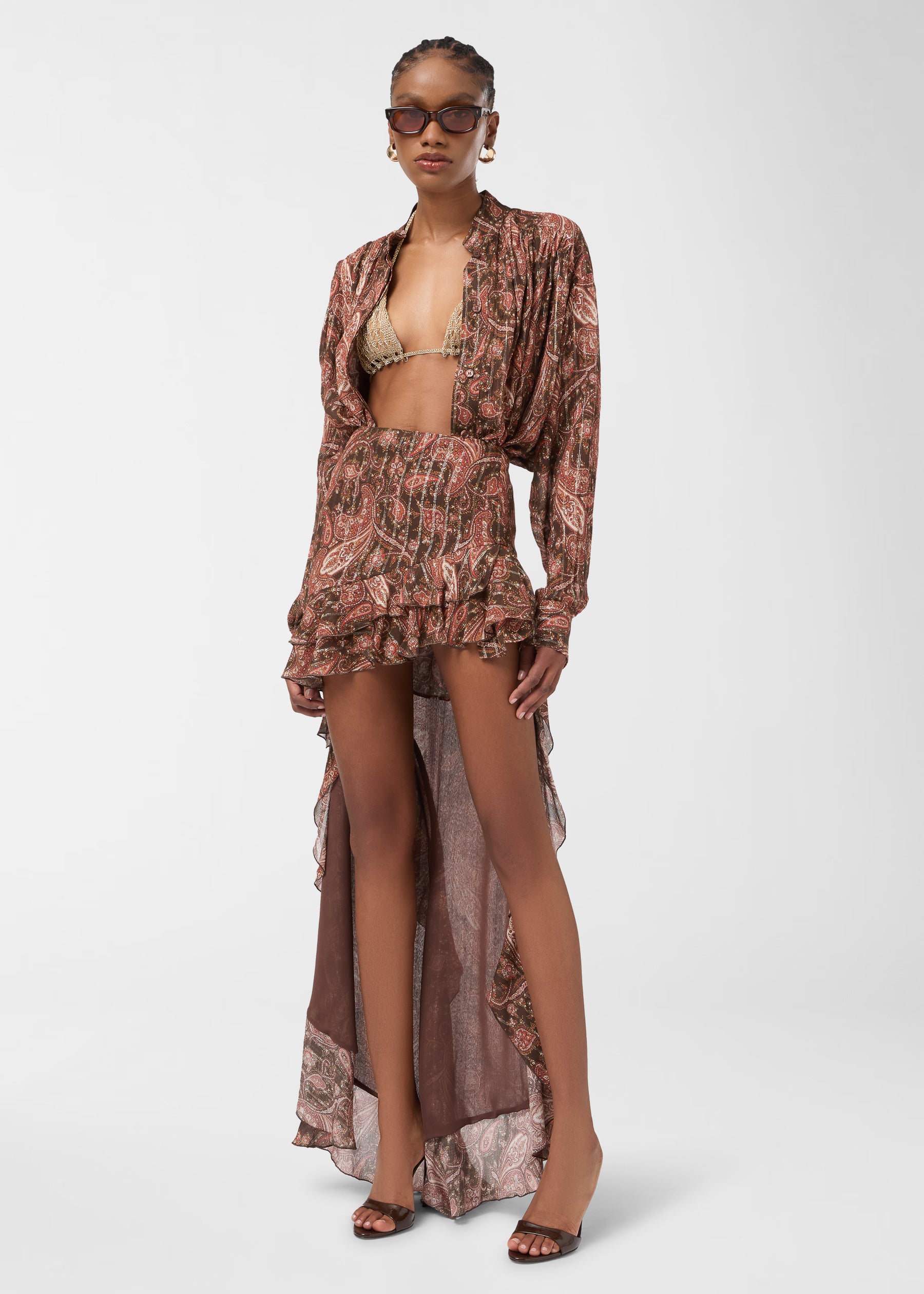 Frontal view: Rania Shirt displayed on model, worn unbuttoned over a bikini top, photographed against a plain studio background, showing paisley georgette, mandarin collar and pleated details.