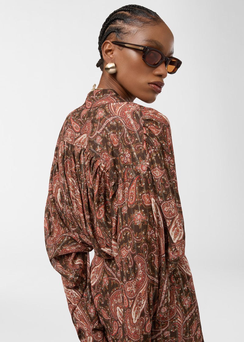 Rear view — Rania Shirt: model wearing paisley-printed georgette oversized shirt, turned over shoulder to show pleated back yoke, mandarin collar, button placket, and flowing drape.